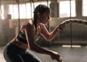 Woman building strength for pegging using gym ropes from BDSM play