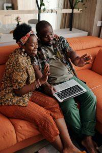 Ruby Ryder shares black couple sitting on couch watching laptop screen and smiling